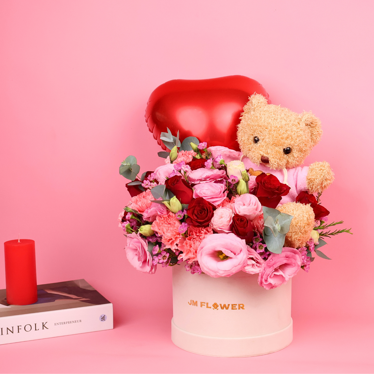 Teddy bear holding pink flower bouquet.