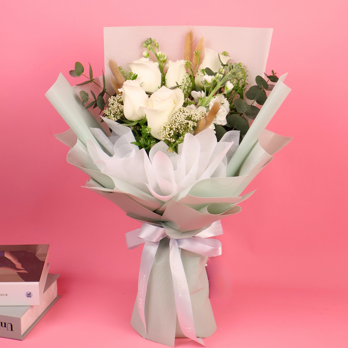 Pink flower bouquet with artificial garden roses in box.