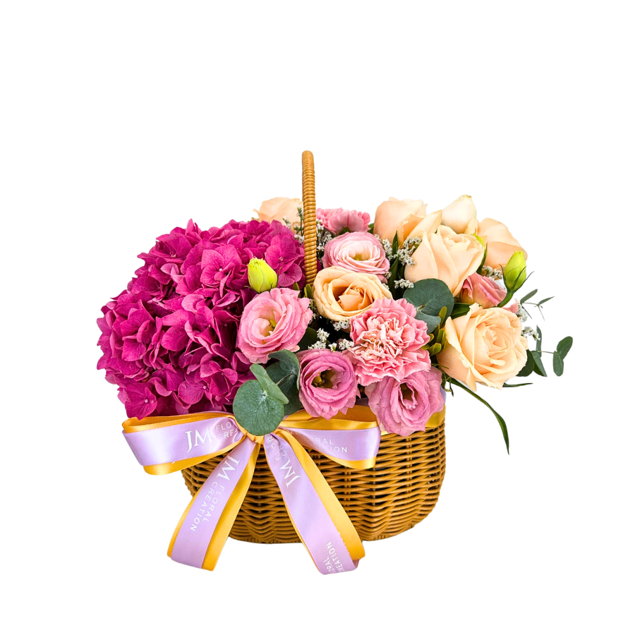 Pink flower bouquet in wicker basket.