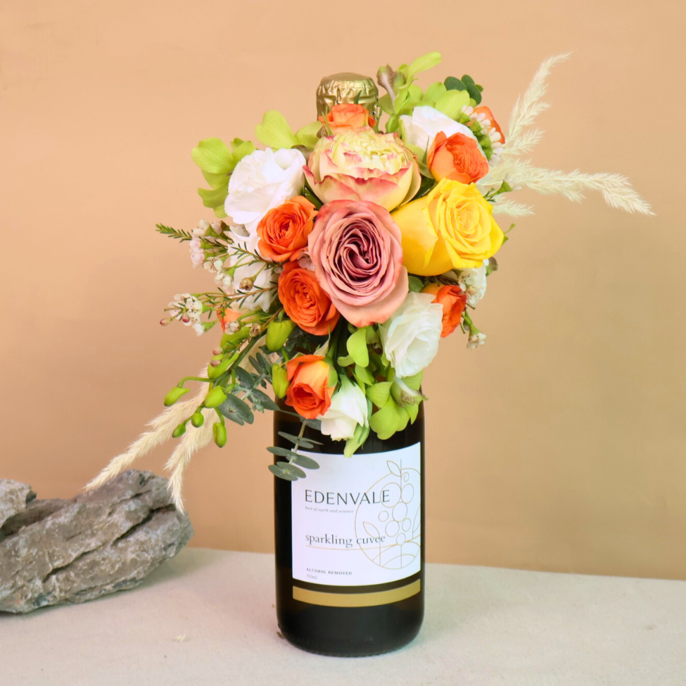 Yellow garden rose bouquet in glass bottle vase.