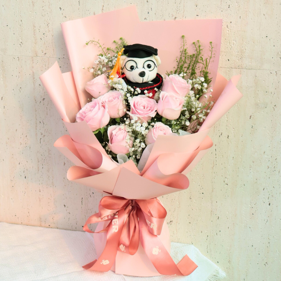 Pink flower bouquet with stuffed toy.