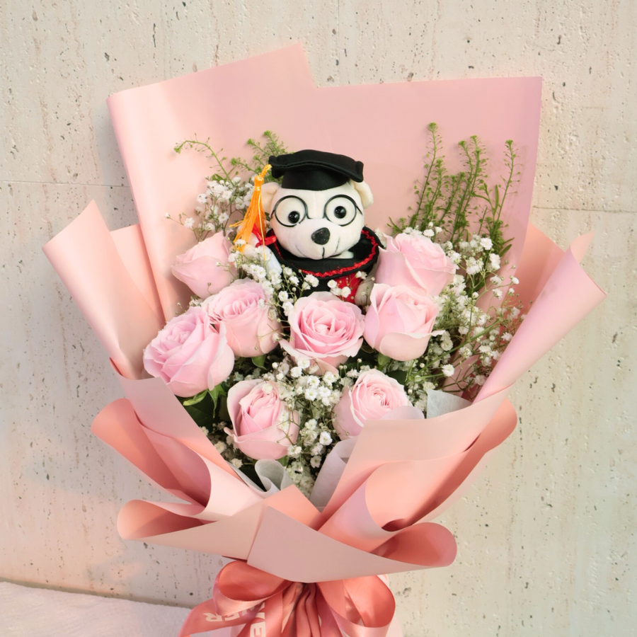 Pink flower bouquet with stuffed toy.