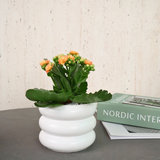 Nordic Inter flowerpot with houseplant and book.
