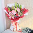 Person arranging red and pink flower bouquet.