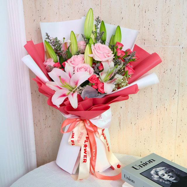 Person arranging red and pink flower bouquet.