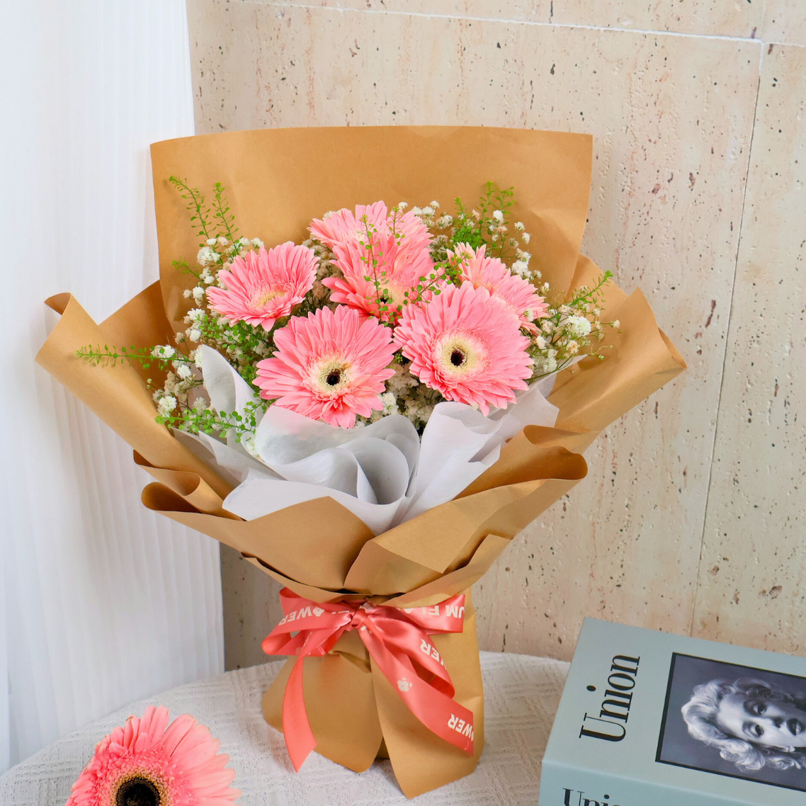 Pink artificial flower bouquet in box.