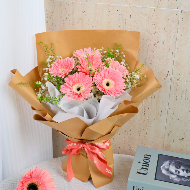 Pink artificial flower bouquet in box.