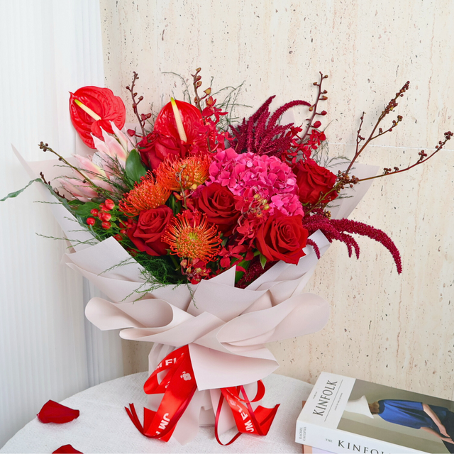 Red and pink flower bouquet in vase.